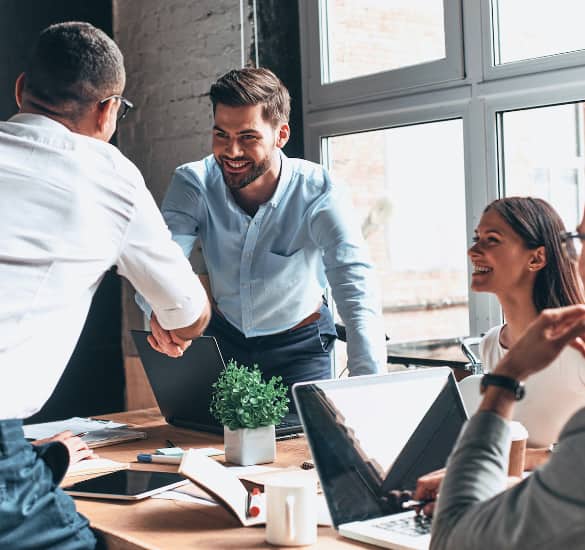 People shaking hands over a conference table