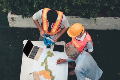 Workers reviewing a blueprint on site