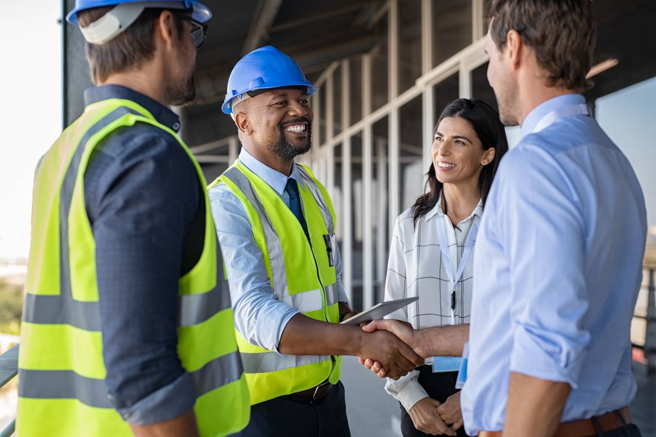 Construction-team-shaking-hands-outside-building-the-samuels-group